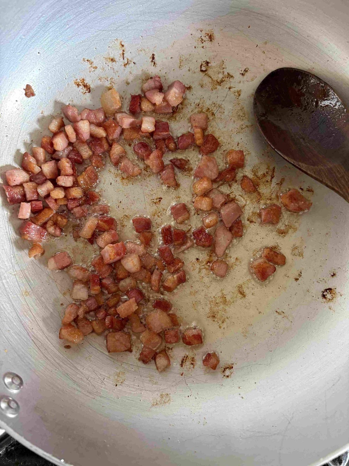 Frying diced guanciale in pan.
