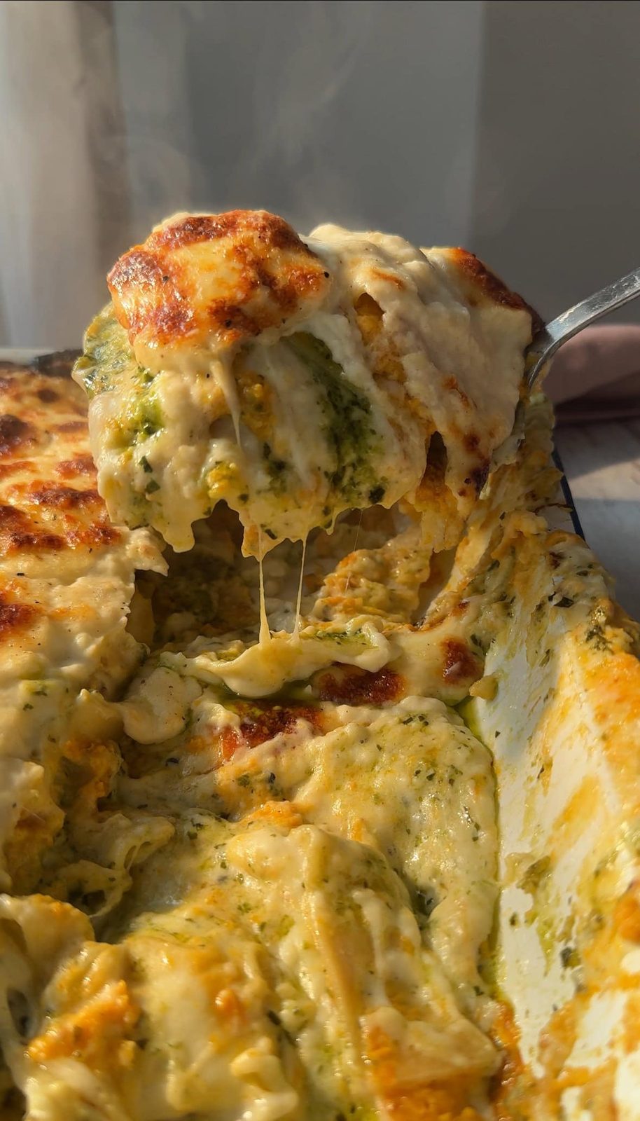 Scooping a portion of lasagne al pesto.
