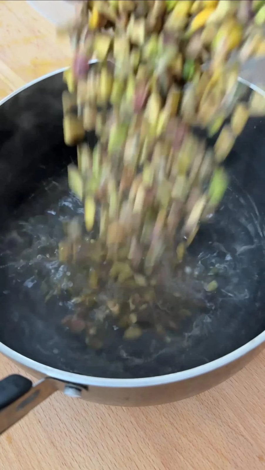adding pistachios to boiling water.