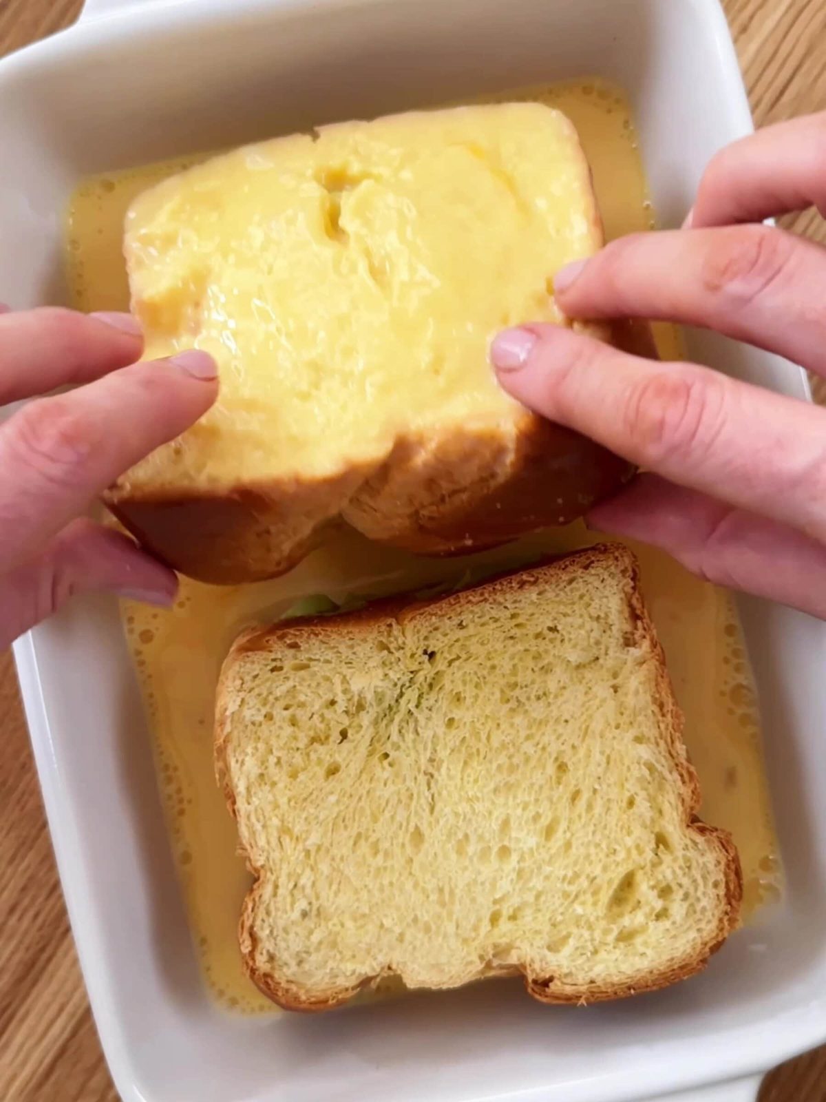 Dipping bread into an egg mixture.
