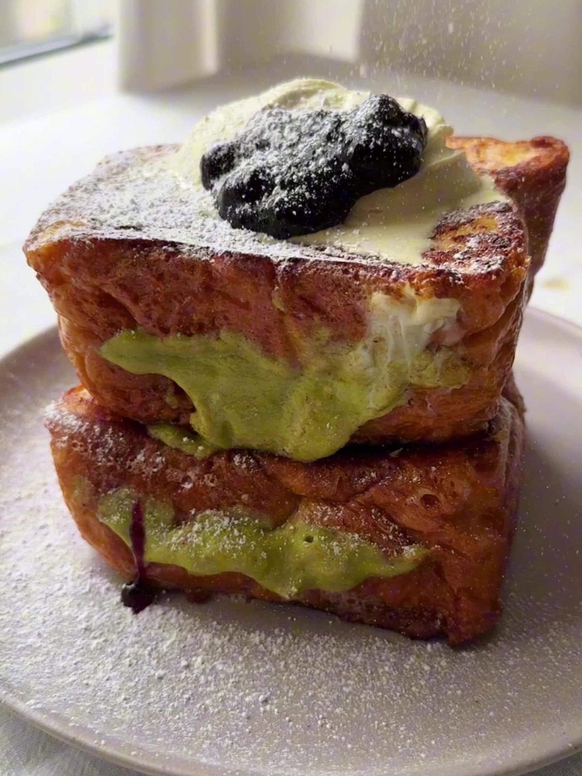 Pistachio Cream Brioche French Toast served in a plate.