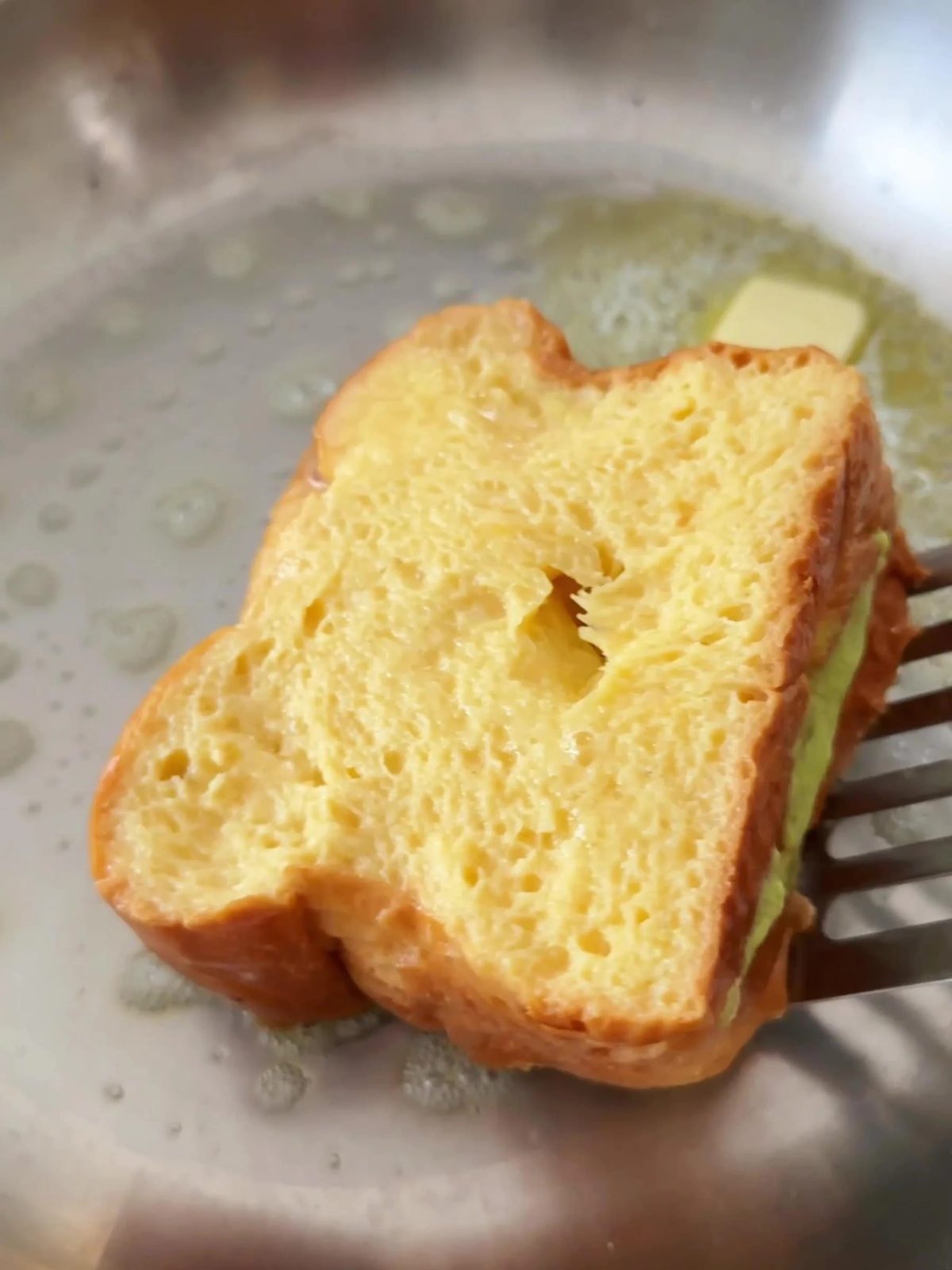 Frying pistachio cream-filled Brioche in a pan.