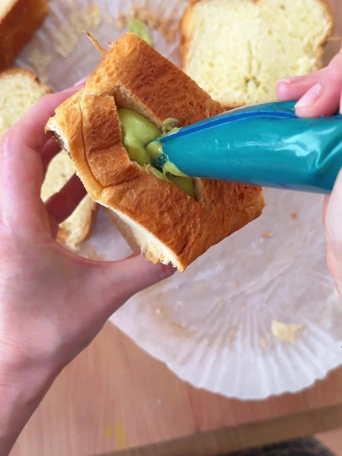 Piping pistachio cream into the Brioche.