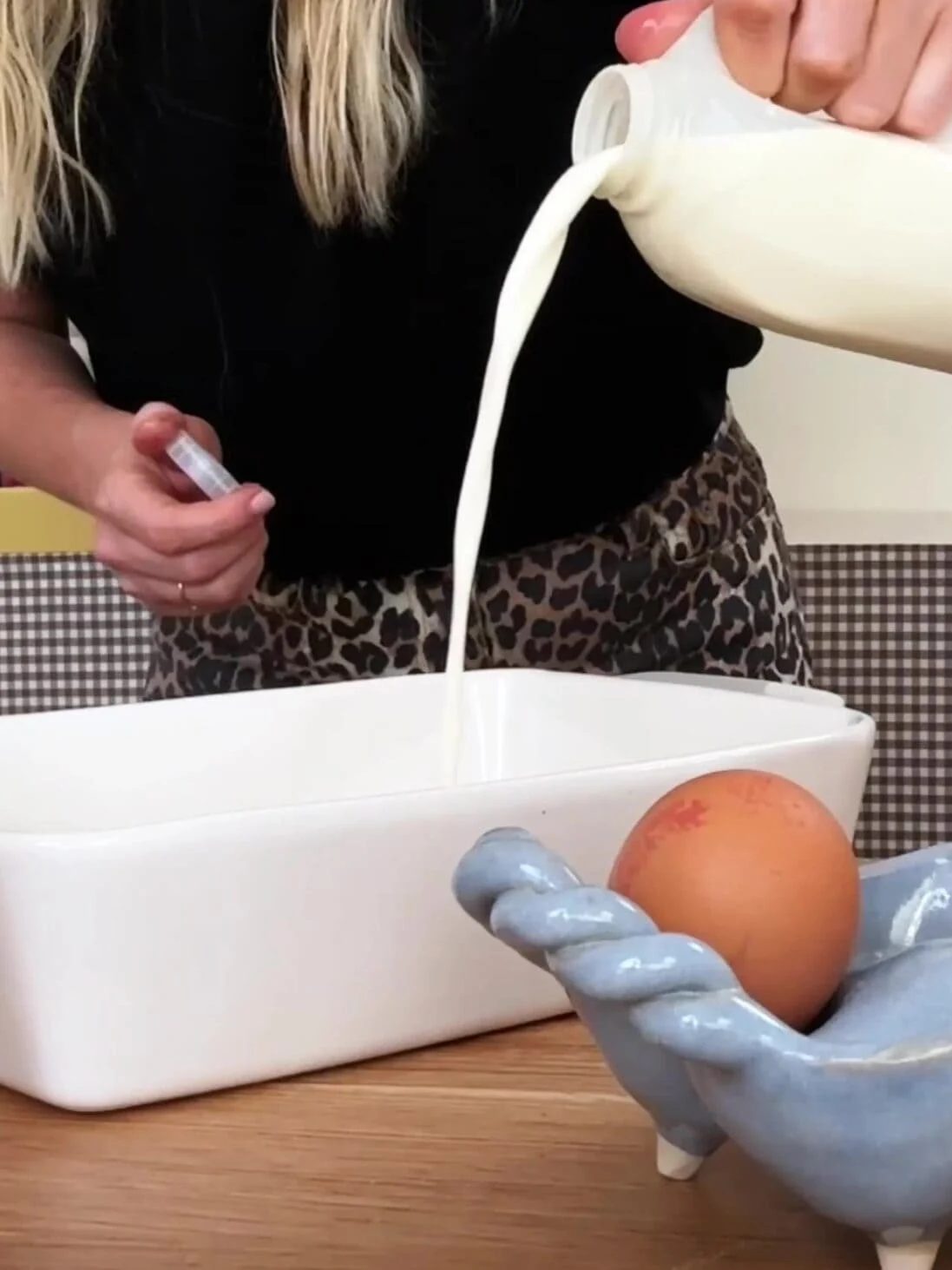 Adding milk to a baking dish.