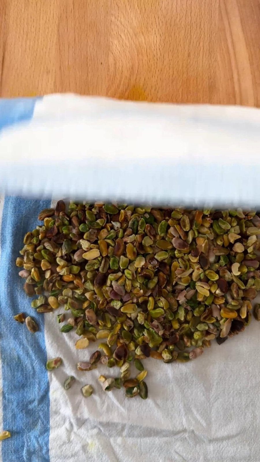 removing skins of pistachios using a kitchen towel.