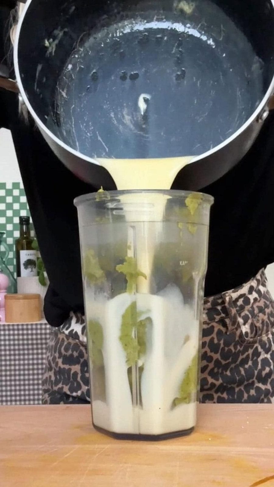 pouring melted white chocolate into pistachio blender.