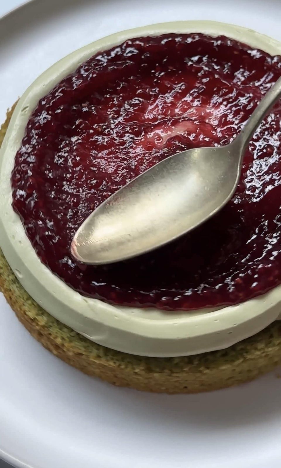 Spreading raspberry jam over cake layers.