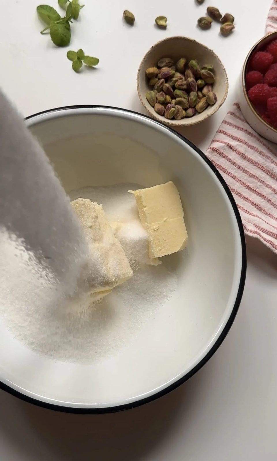 Creaming butter and sugar together in white mixing bowl.