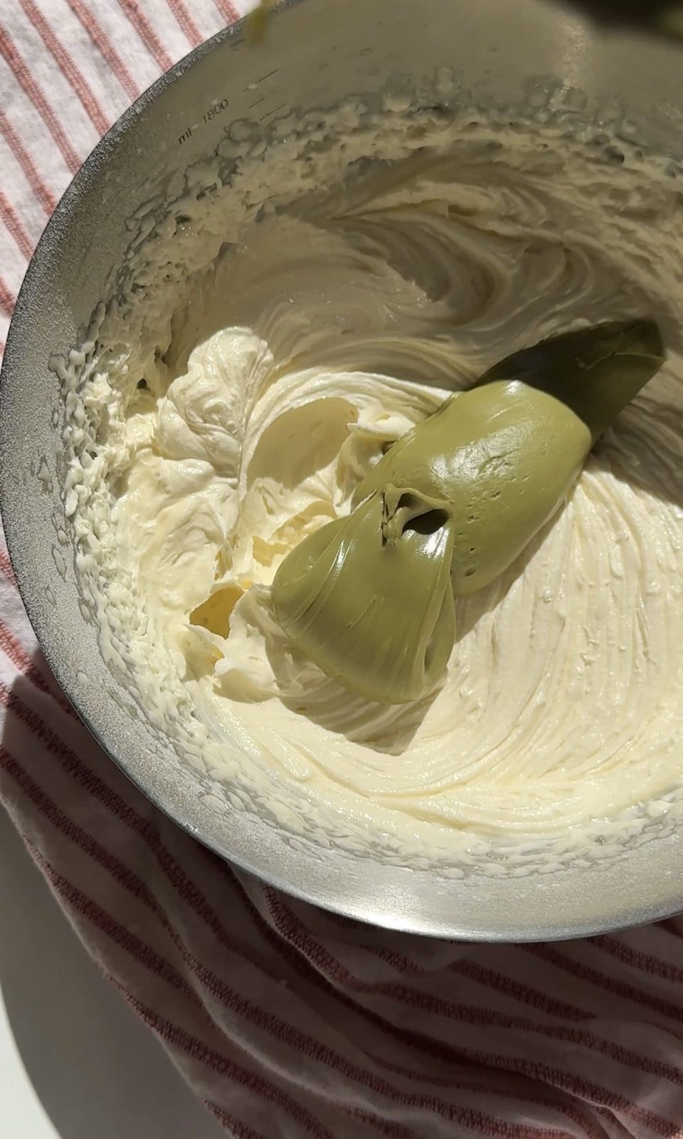 Adding pistachio cream to the icing.