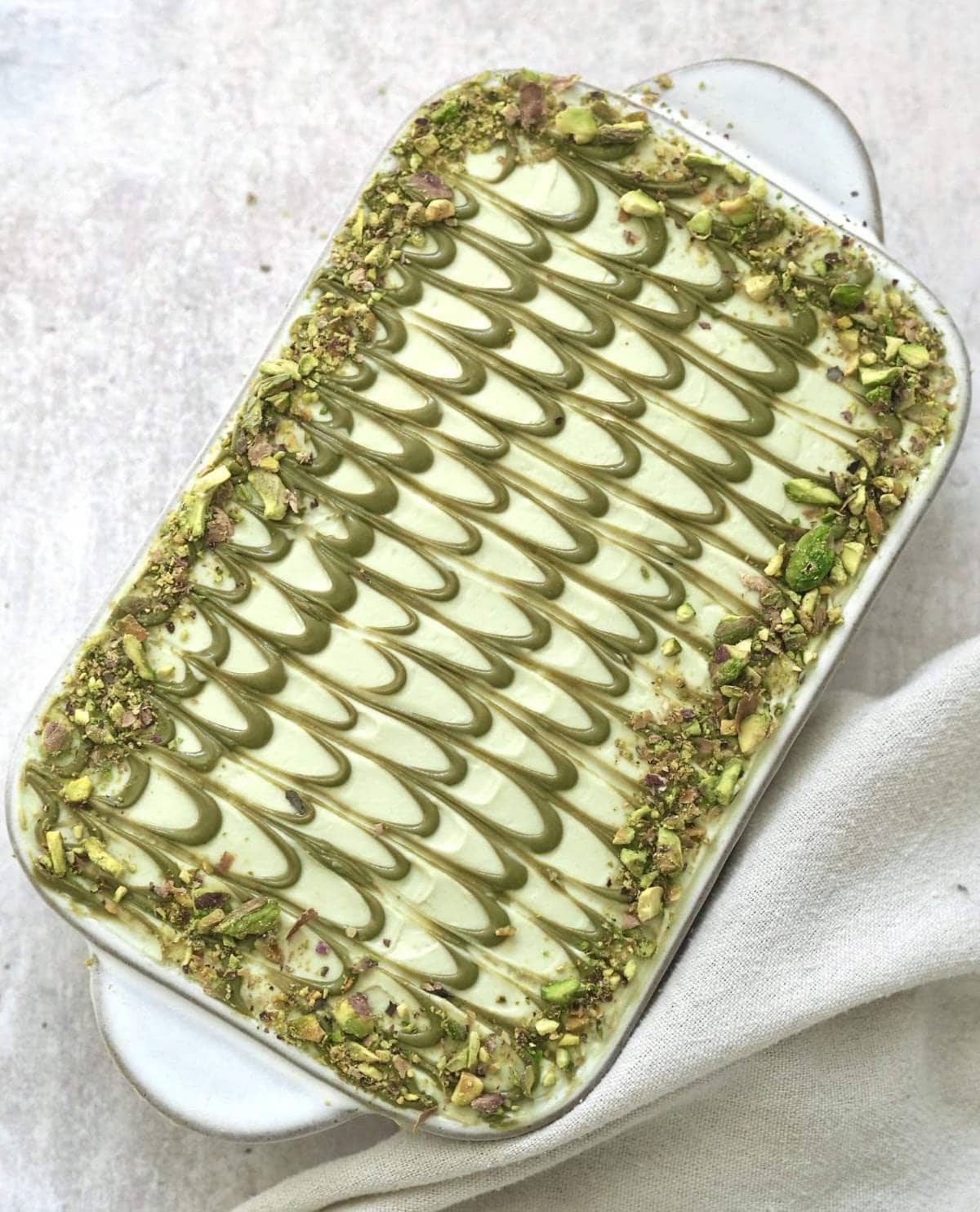 Pistachio tiramisu in white dish.