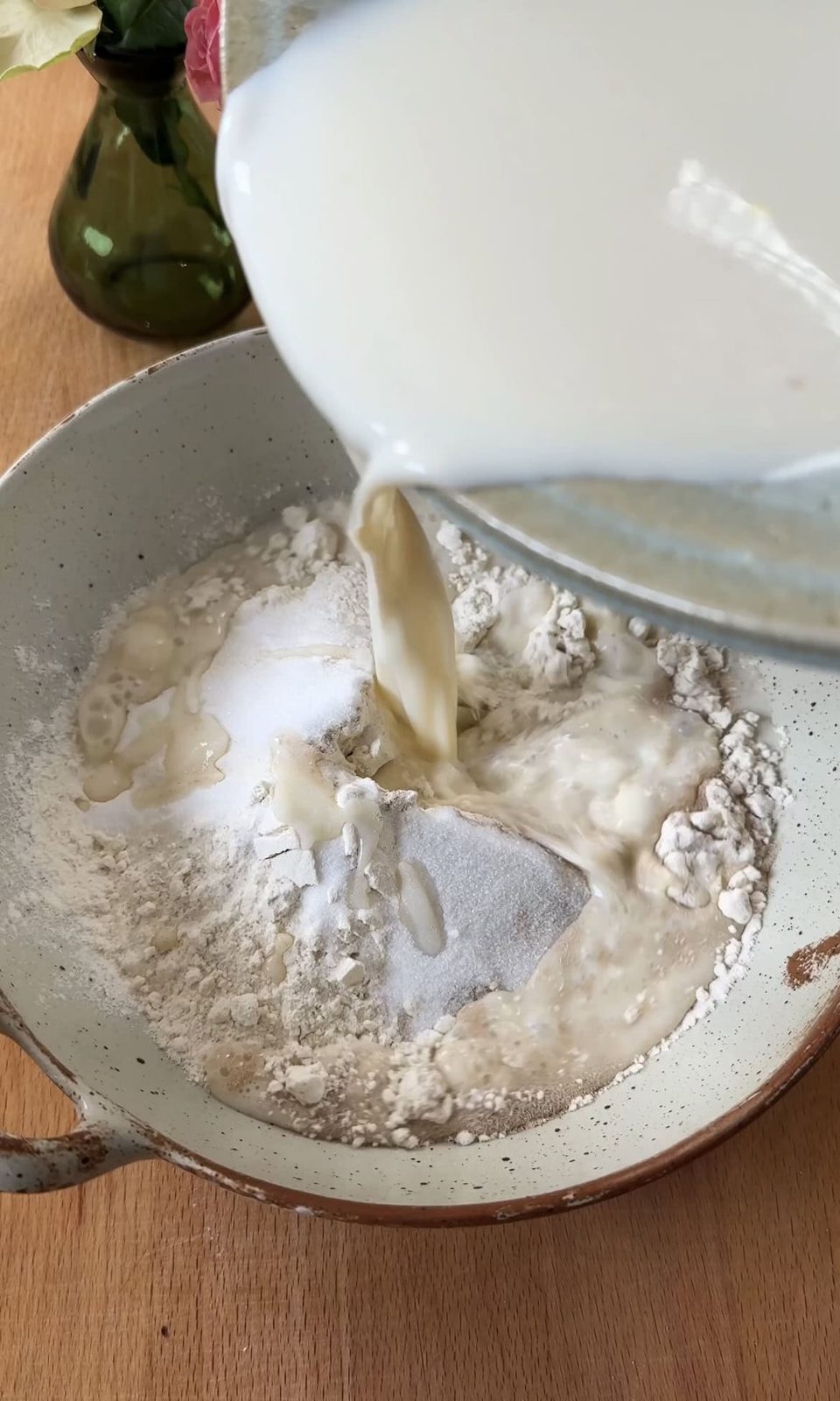 Adding milk to poffertjes batter.