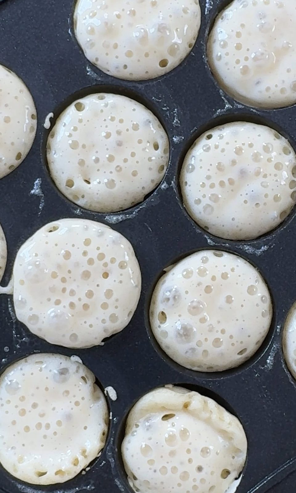 Frying poffertjes in pan.