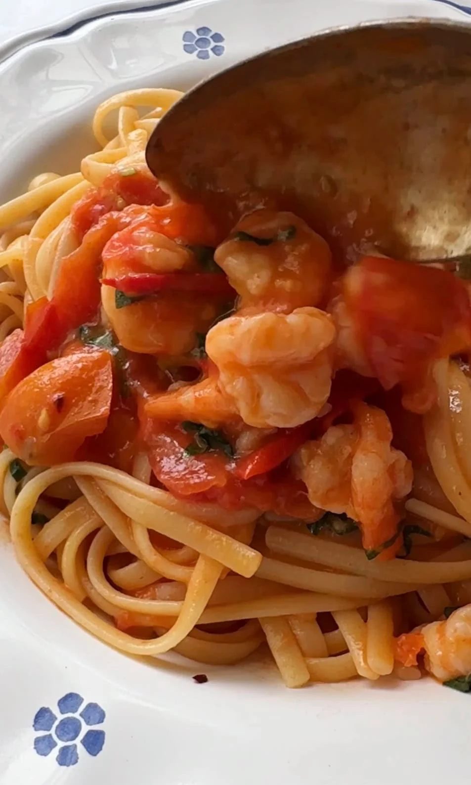 Serving prawn tomato linguine on plate.