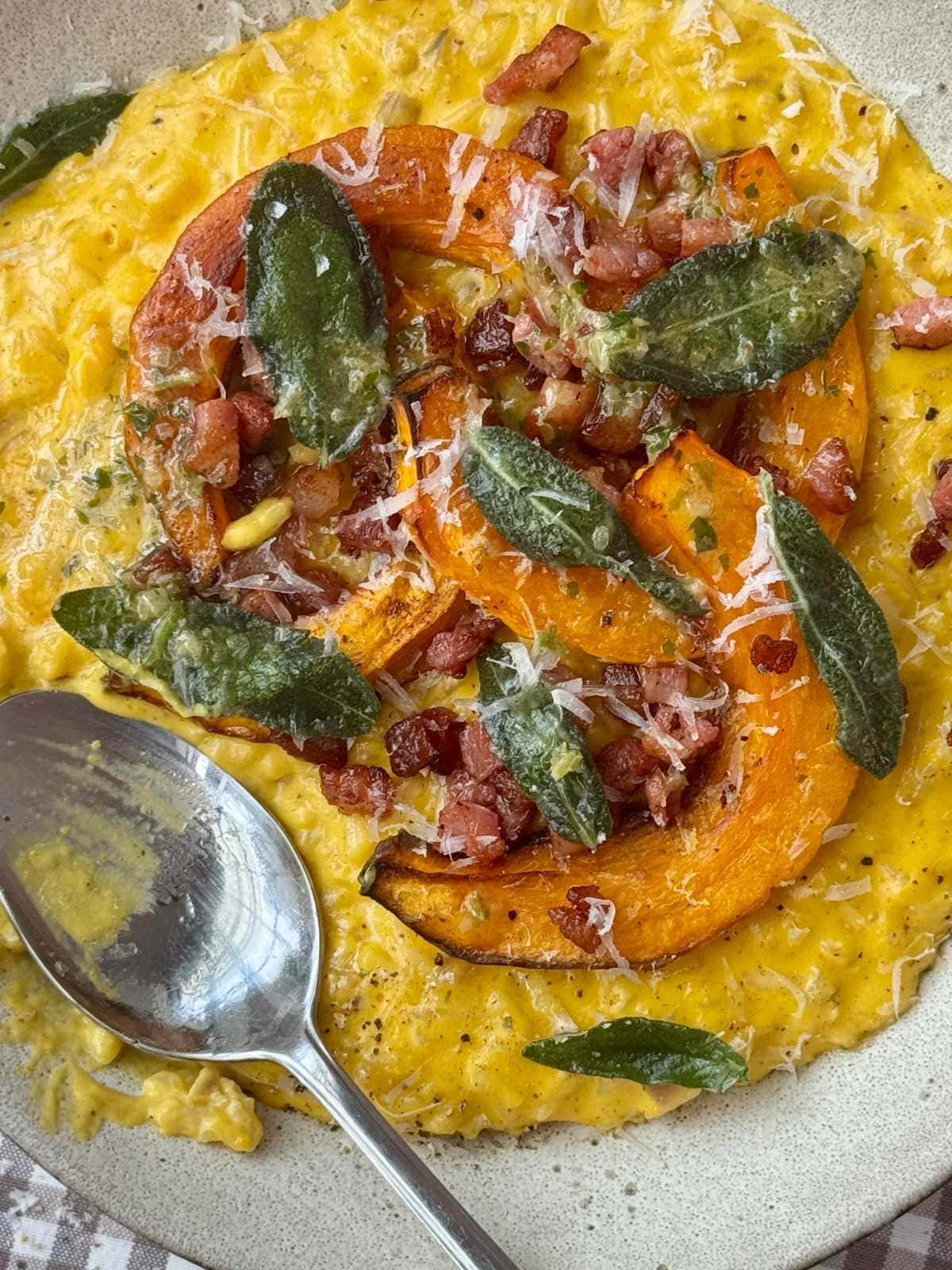 pumpkin risotto in a grey bowl with a spoon.