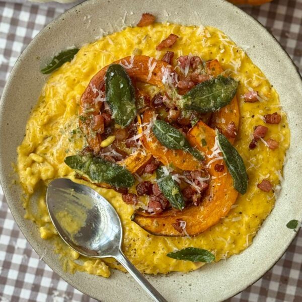 pumpkin risotto in a grey bowl with a spoon.