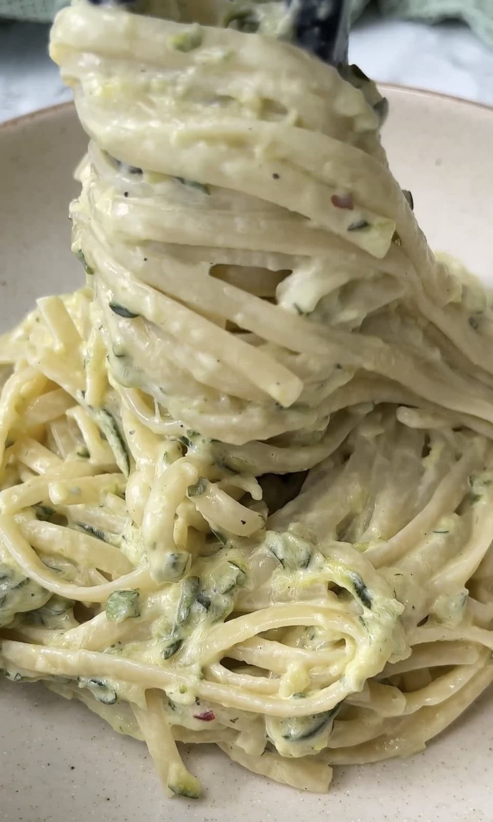 adding the courgette pasta to the bowl.