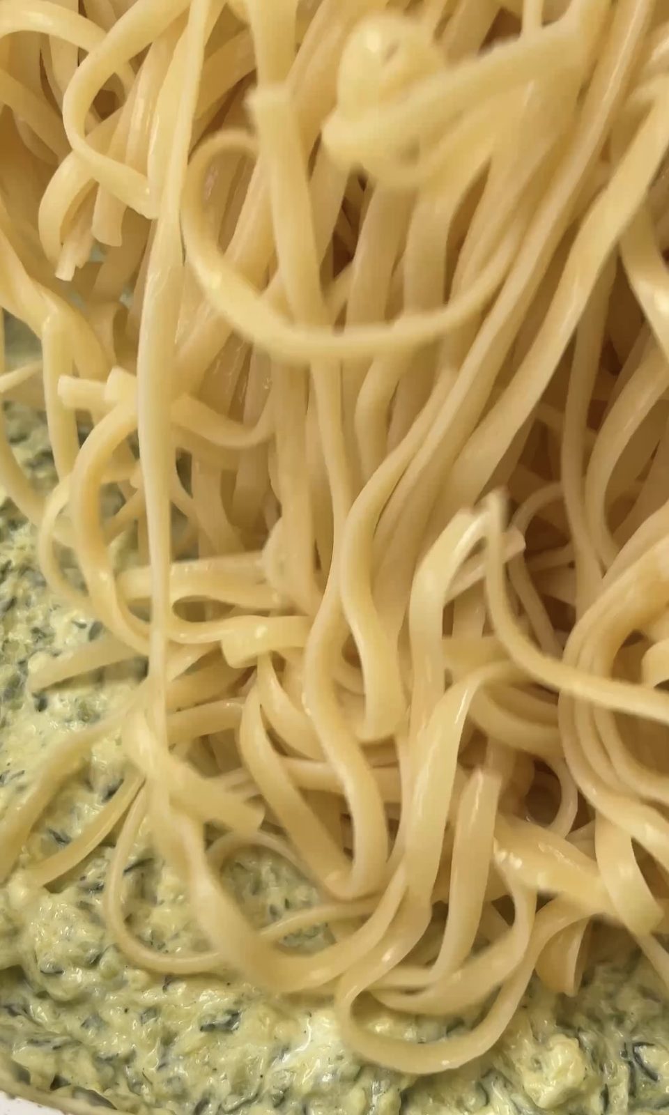 adding linguine to courgette sauce.