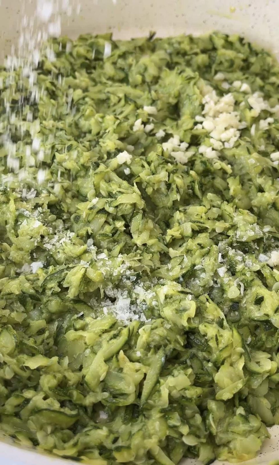 adding garlic to courgette pasta sauce.