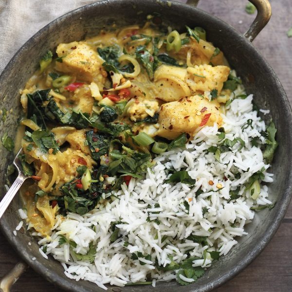 Fish curry in a metal serving dish with coriander rice.