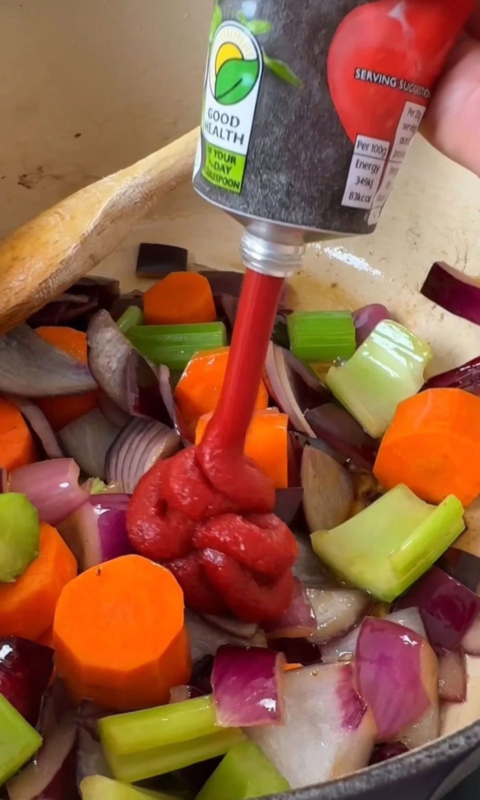 Stirring tomato paste and red wine into braised short rib sauce.