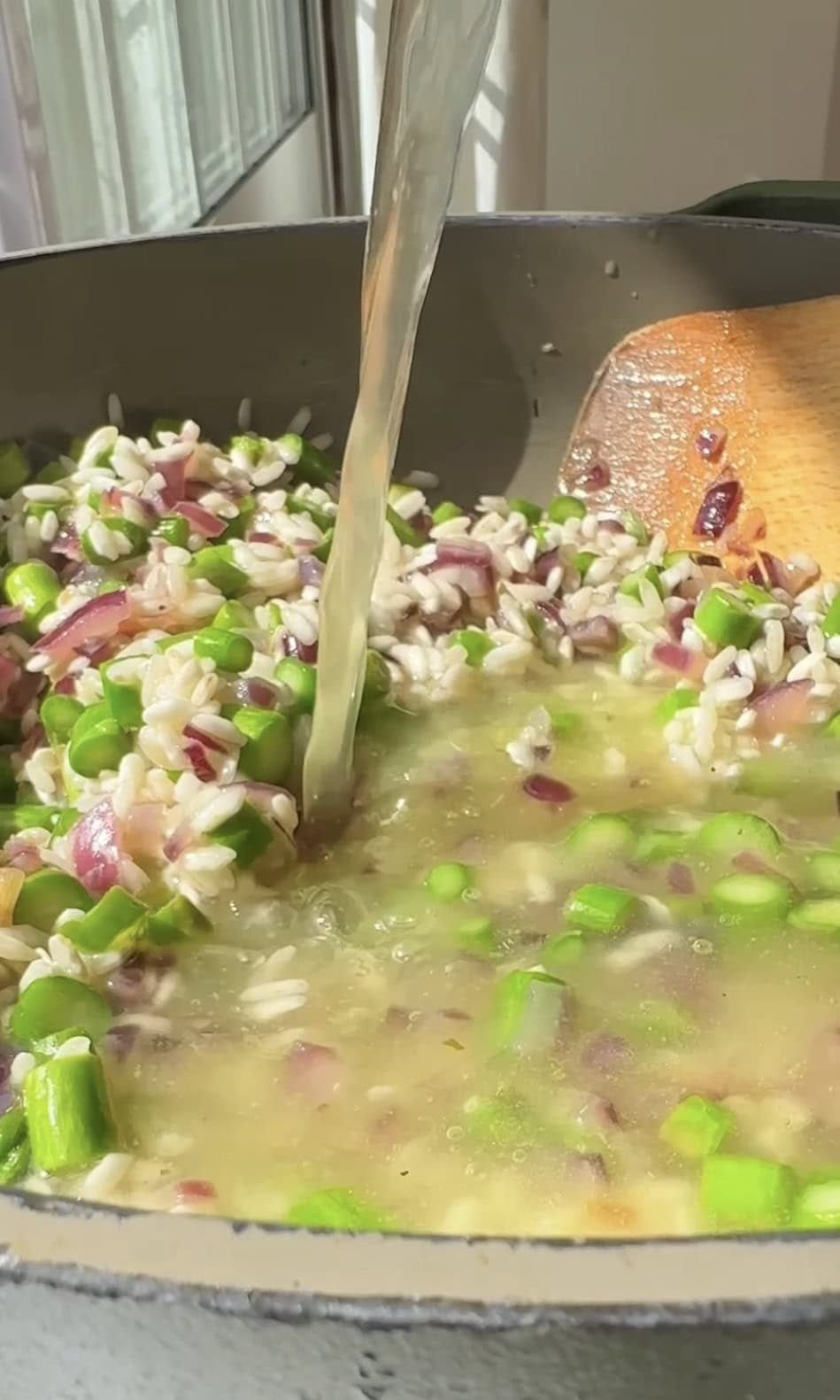 adding stock to the risotto.