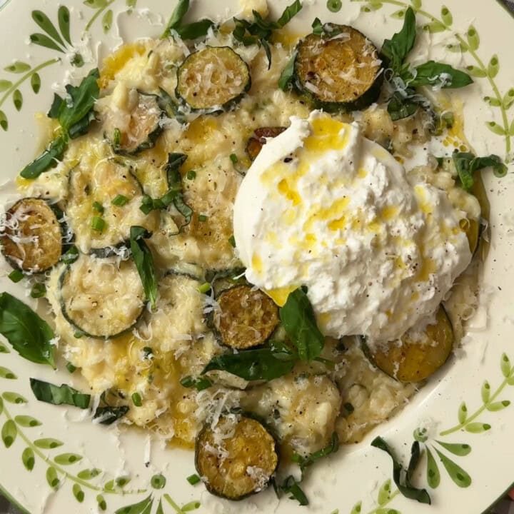 creamy zucchini risotto in a bowl with mozzarella on top.