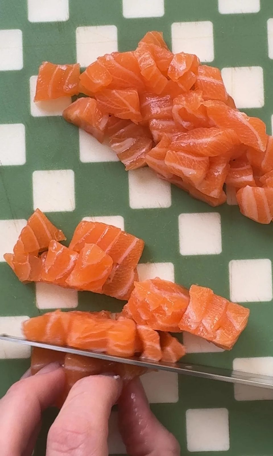 Slicing raw salmon with a knife.