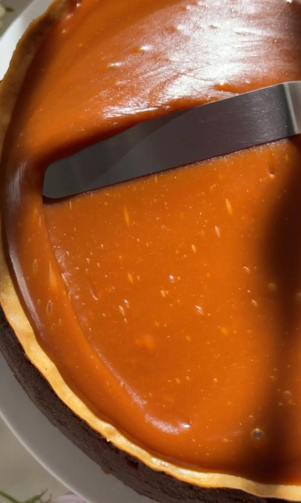 smoothing salted caramel on the cheesecake base.