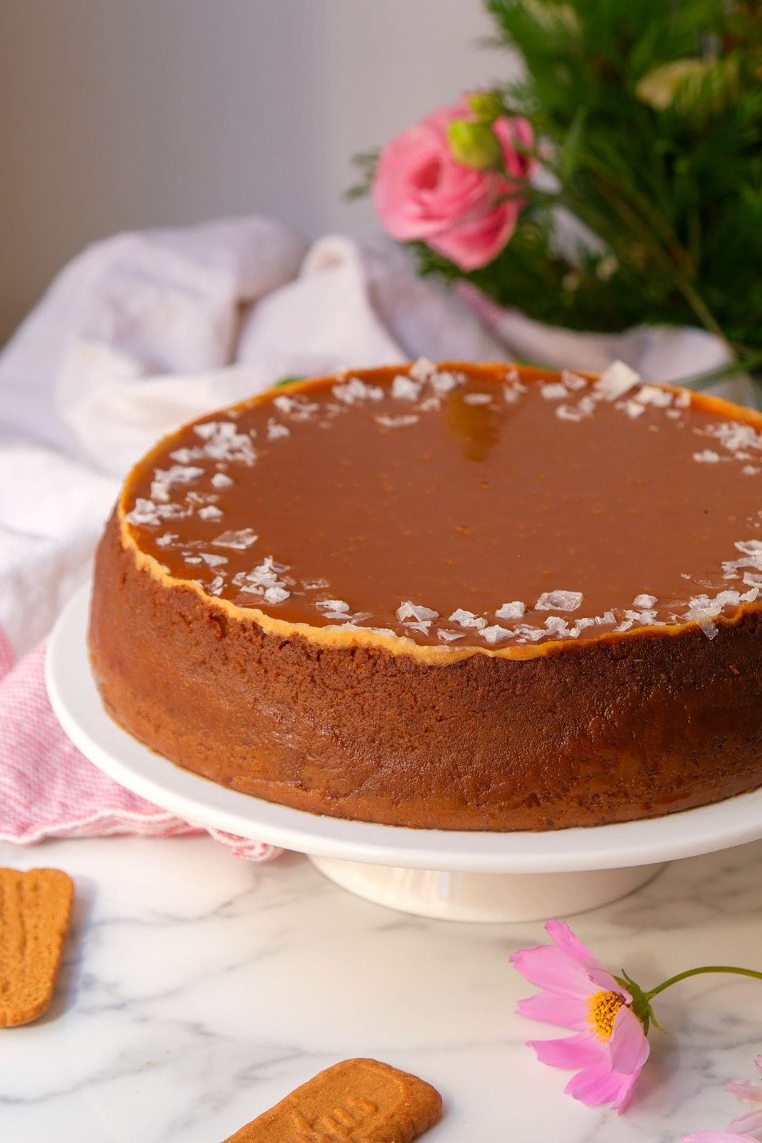 whole salted caramel cheesecake on a cake platter.