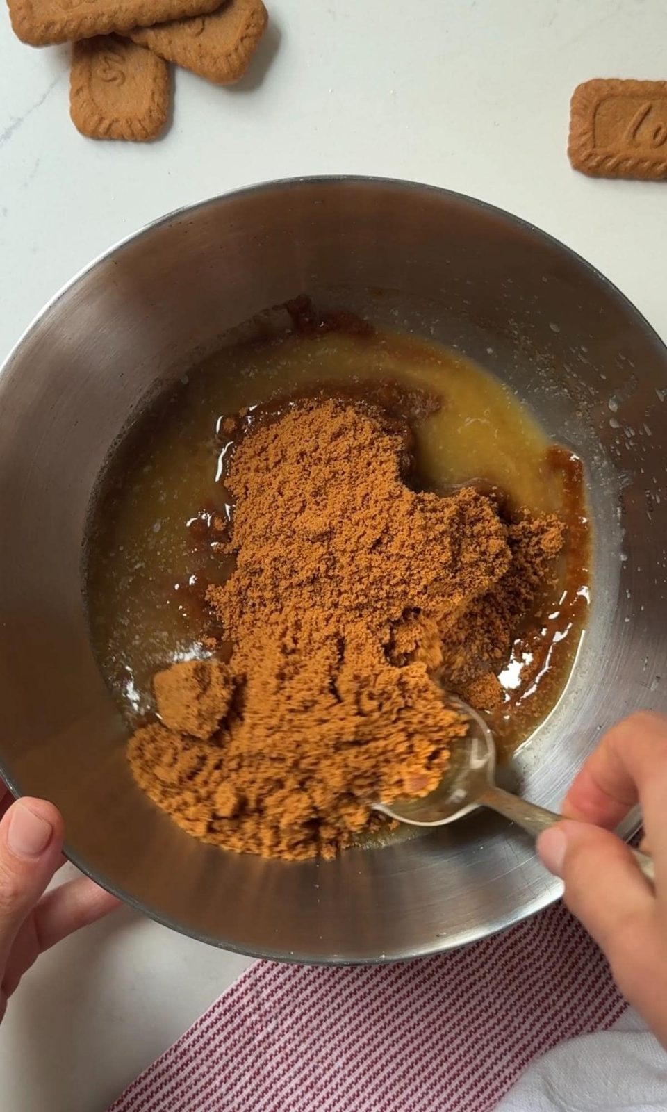 mixing melted butter with the biscuits.