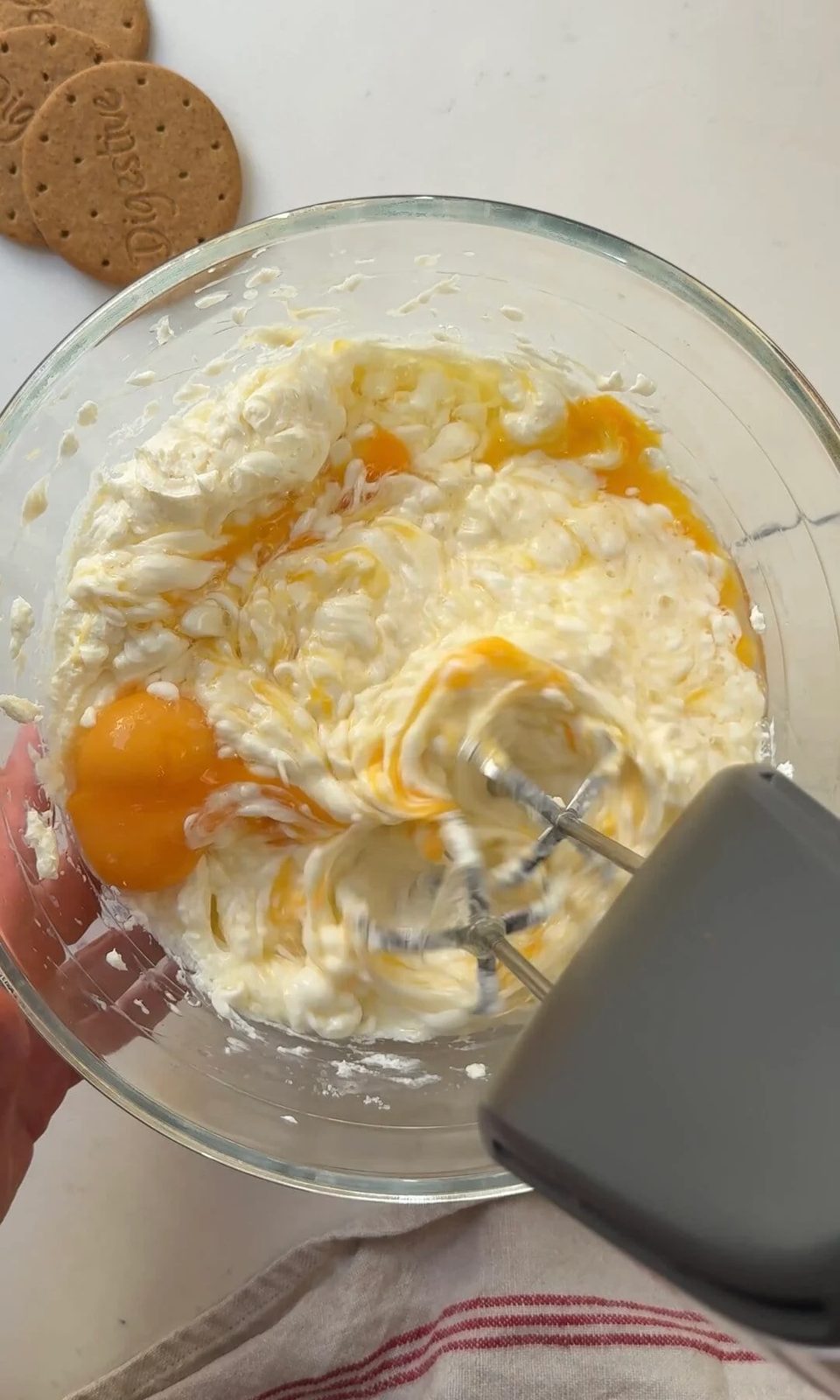 whisking eggs into the cheesecake base.