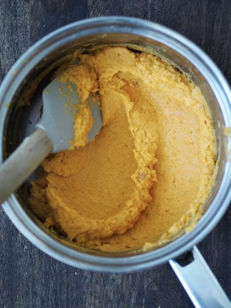Sweet potato mash being stirred with a rubber spatula.