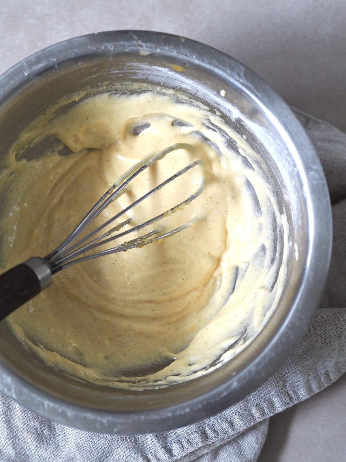 Cake batter ingredients being whisked in a metal bowl.