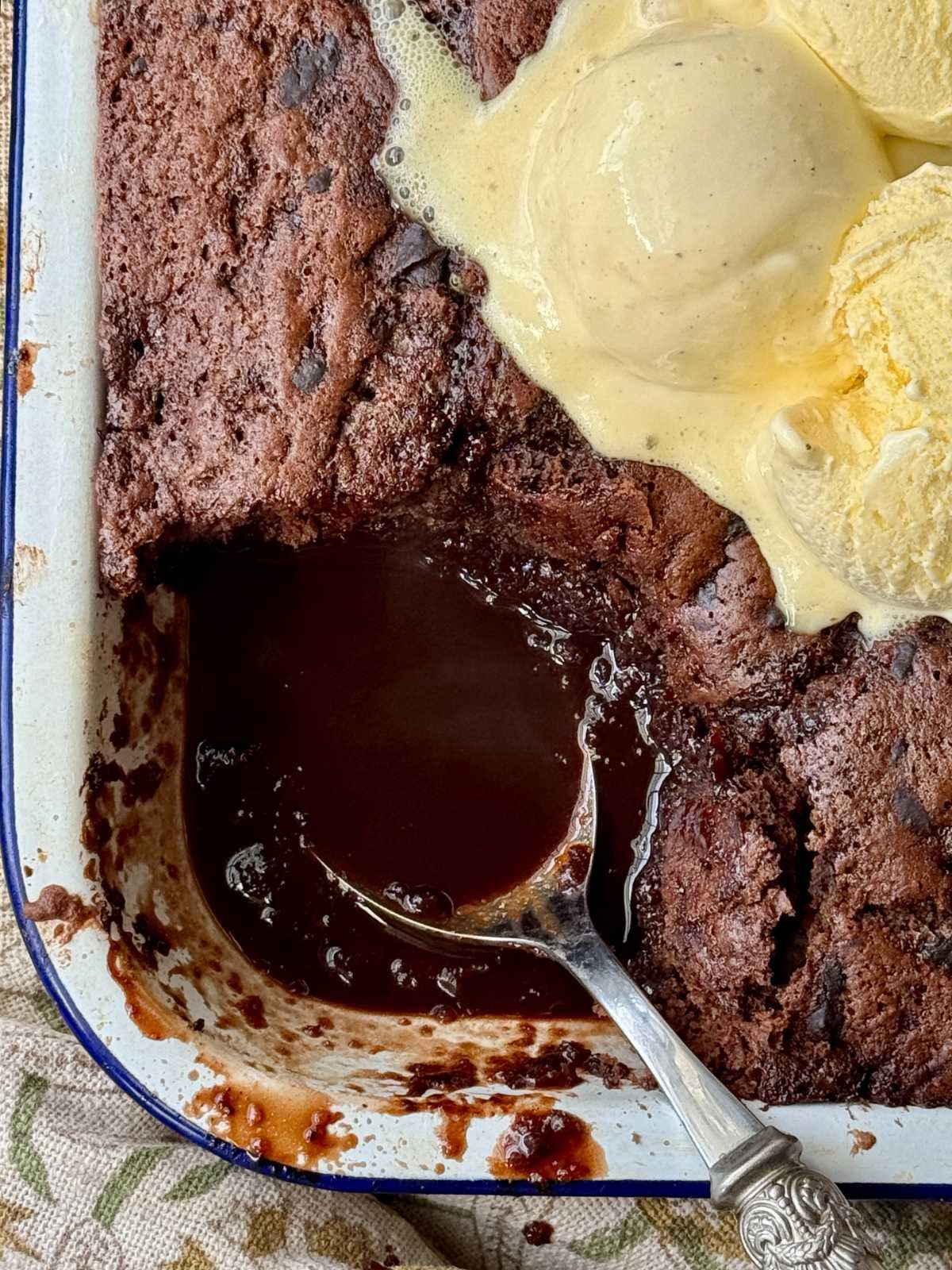 self saucing chocolate pudding in enamel dish with ice cream on top.