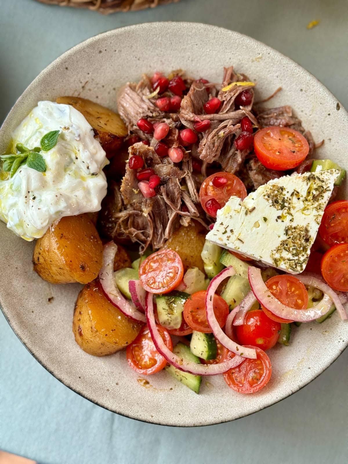 slow cooked lamb with potatoes and greek salad.