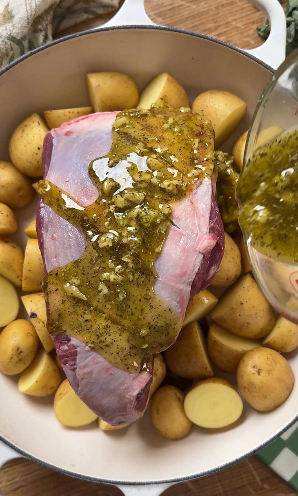 pouring marinade over the lamb.