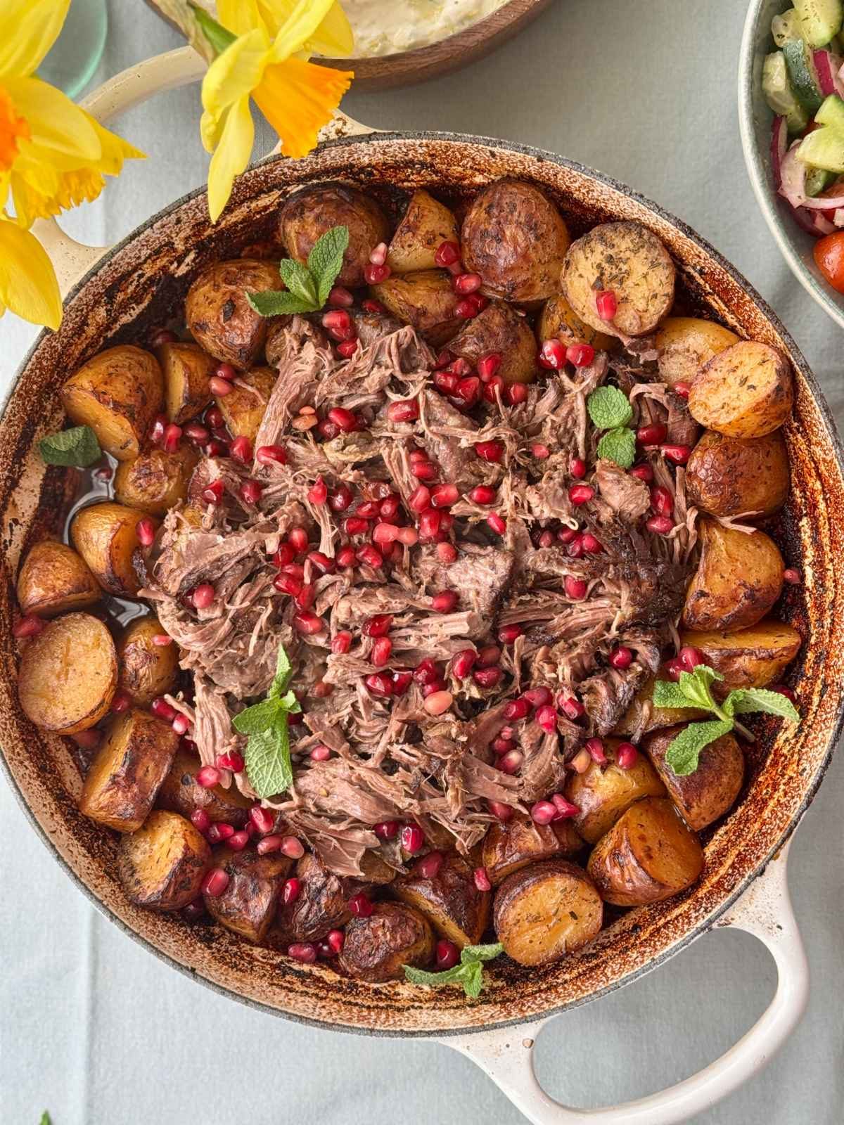 slow cooked lamb with potatoes in a tray.