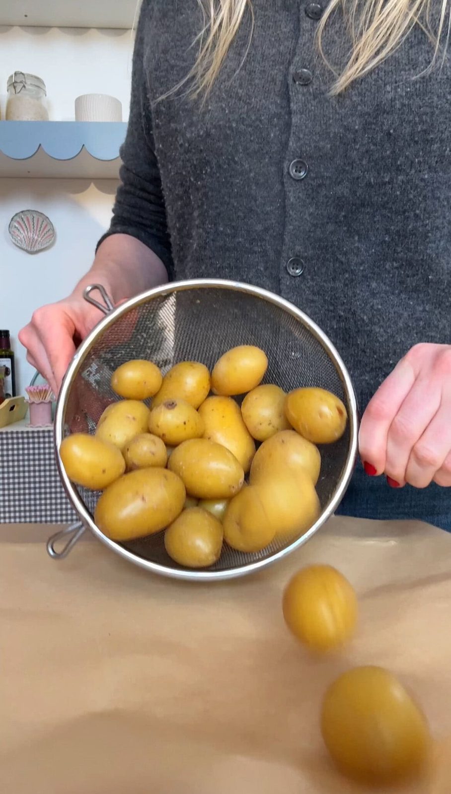 Pouring boiled potatoes onto parchment paper.