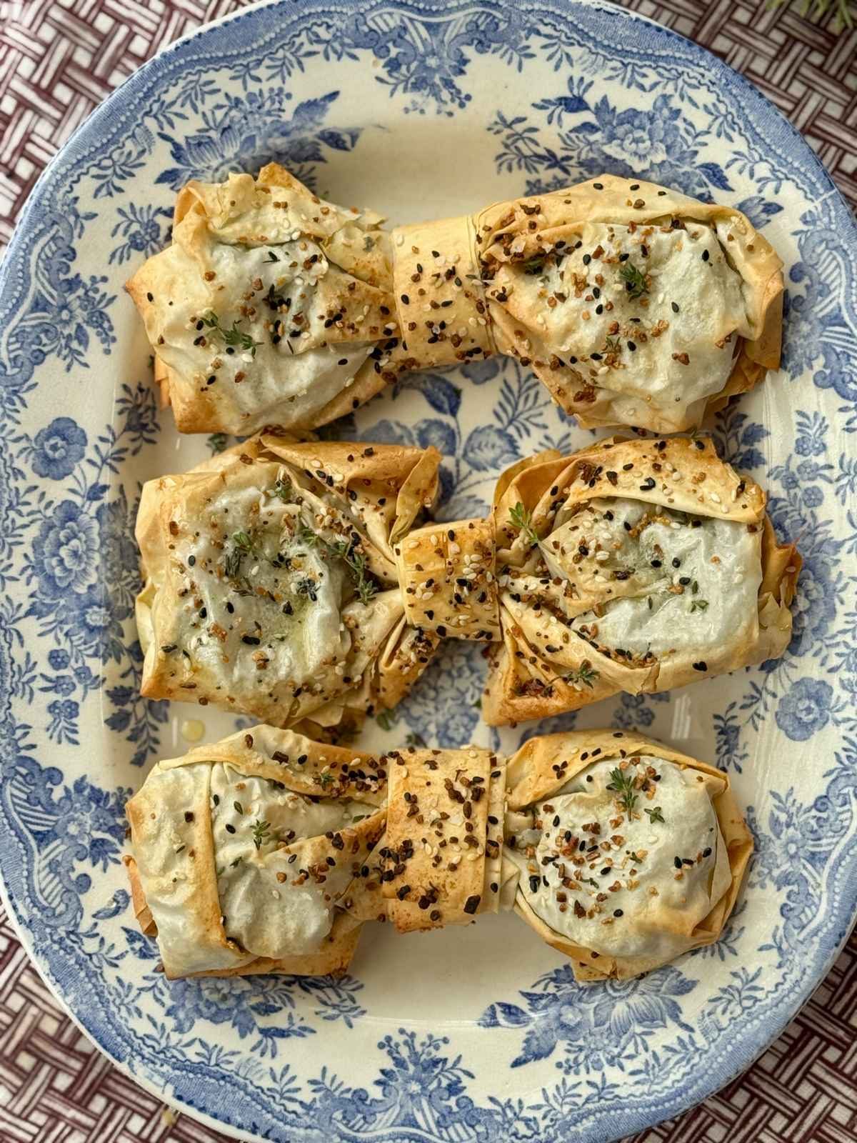 spinach feta filos bows on a blue plate.