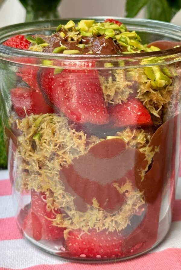 a glass filled with dubai chocolate strawberry.