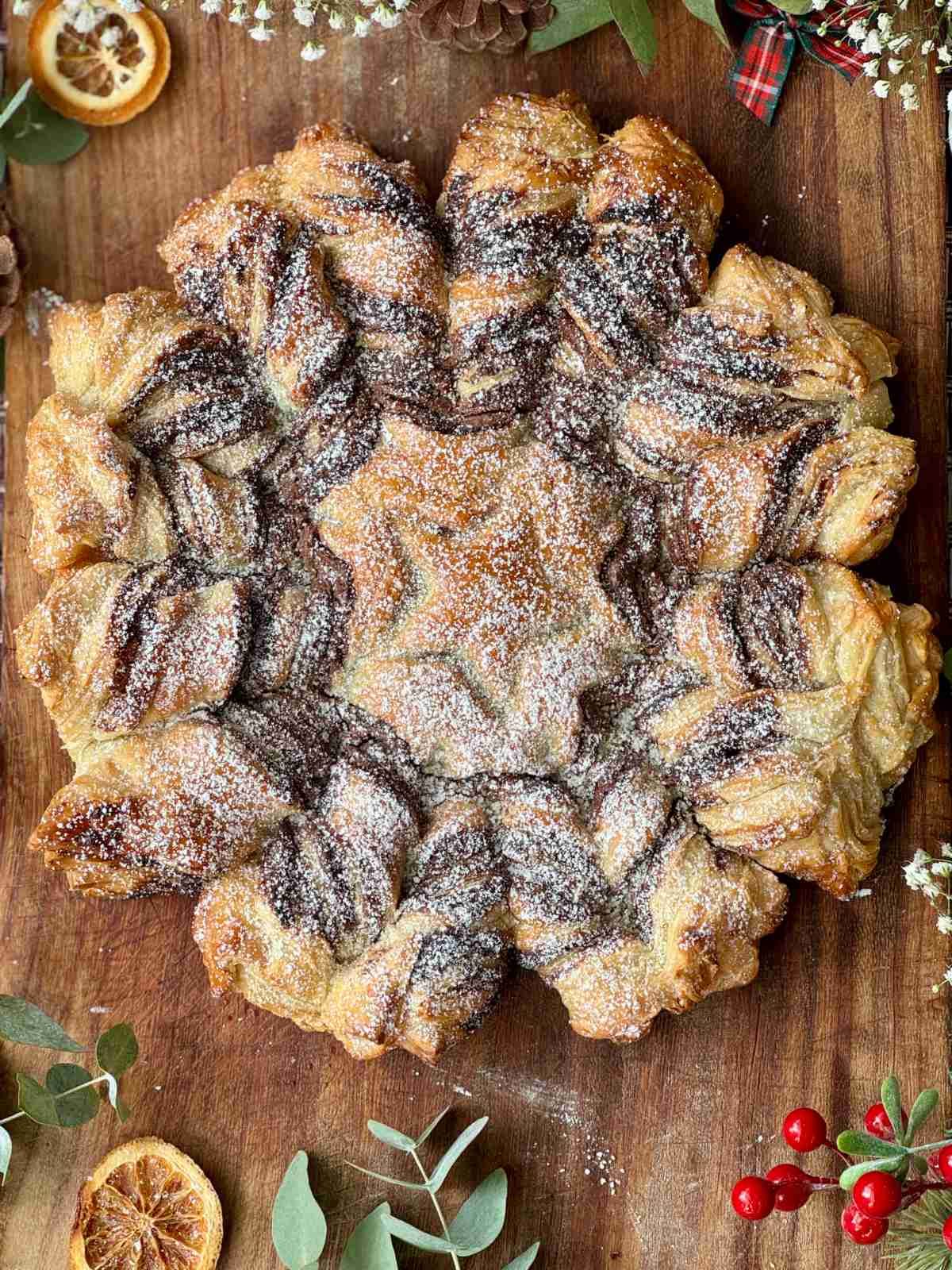 tarte soleil on a board with icing sugar.