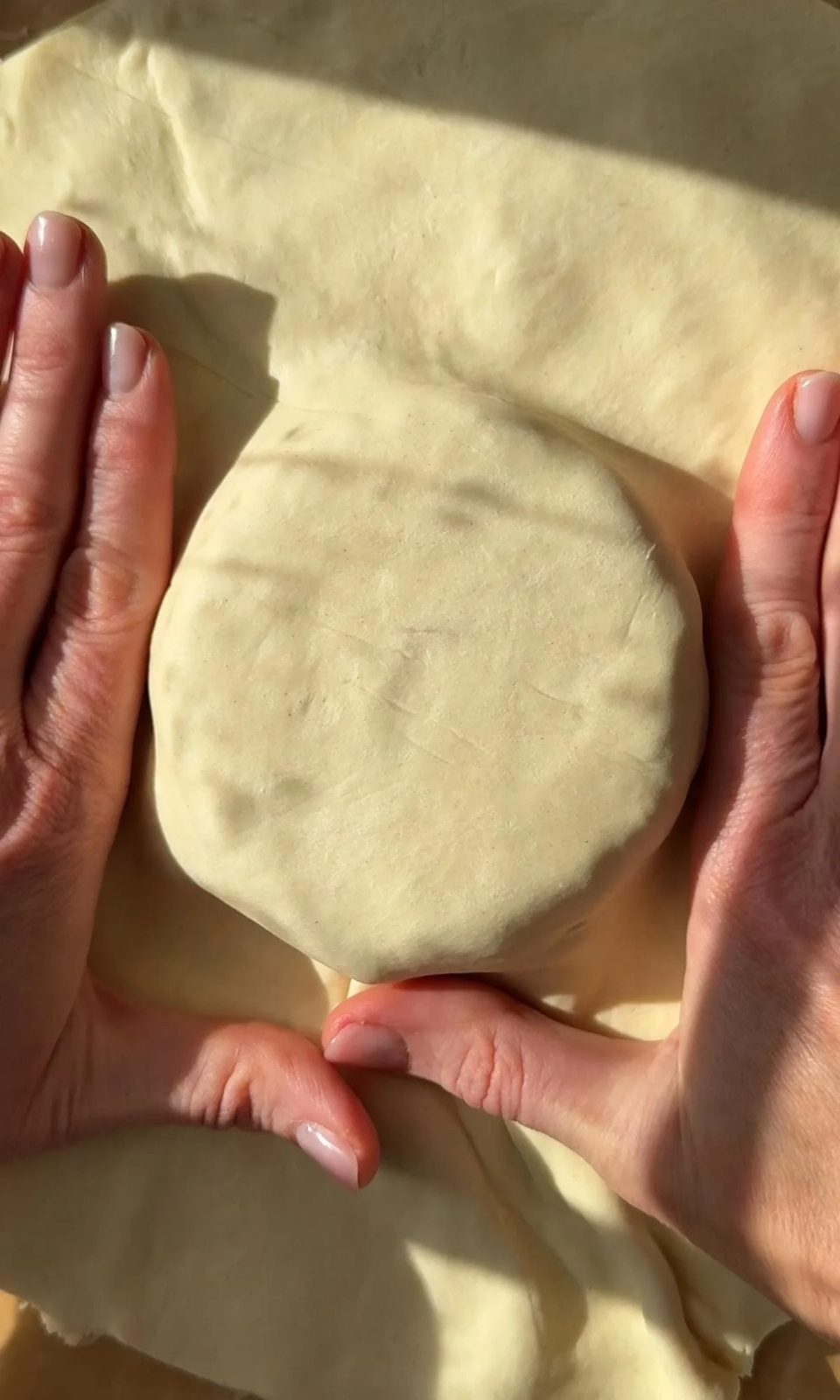 Pressing puff pastry over Brie.