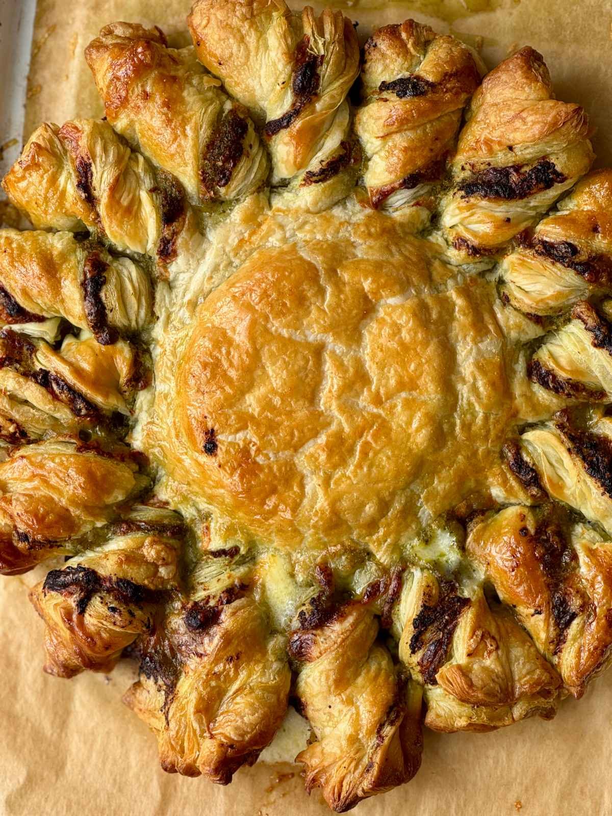 Tarte soleil with pesto and melted brie covered in pastry.