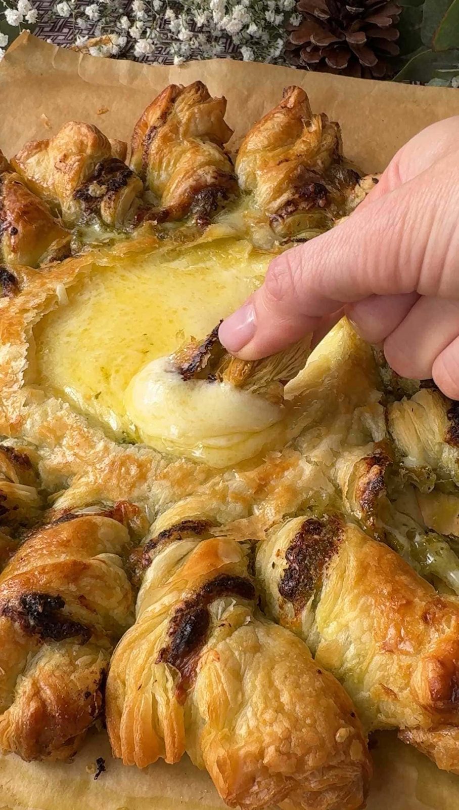 Dipping baked puffed pastry in melted Brie.