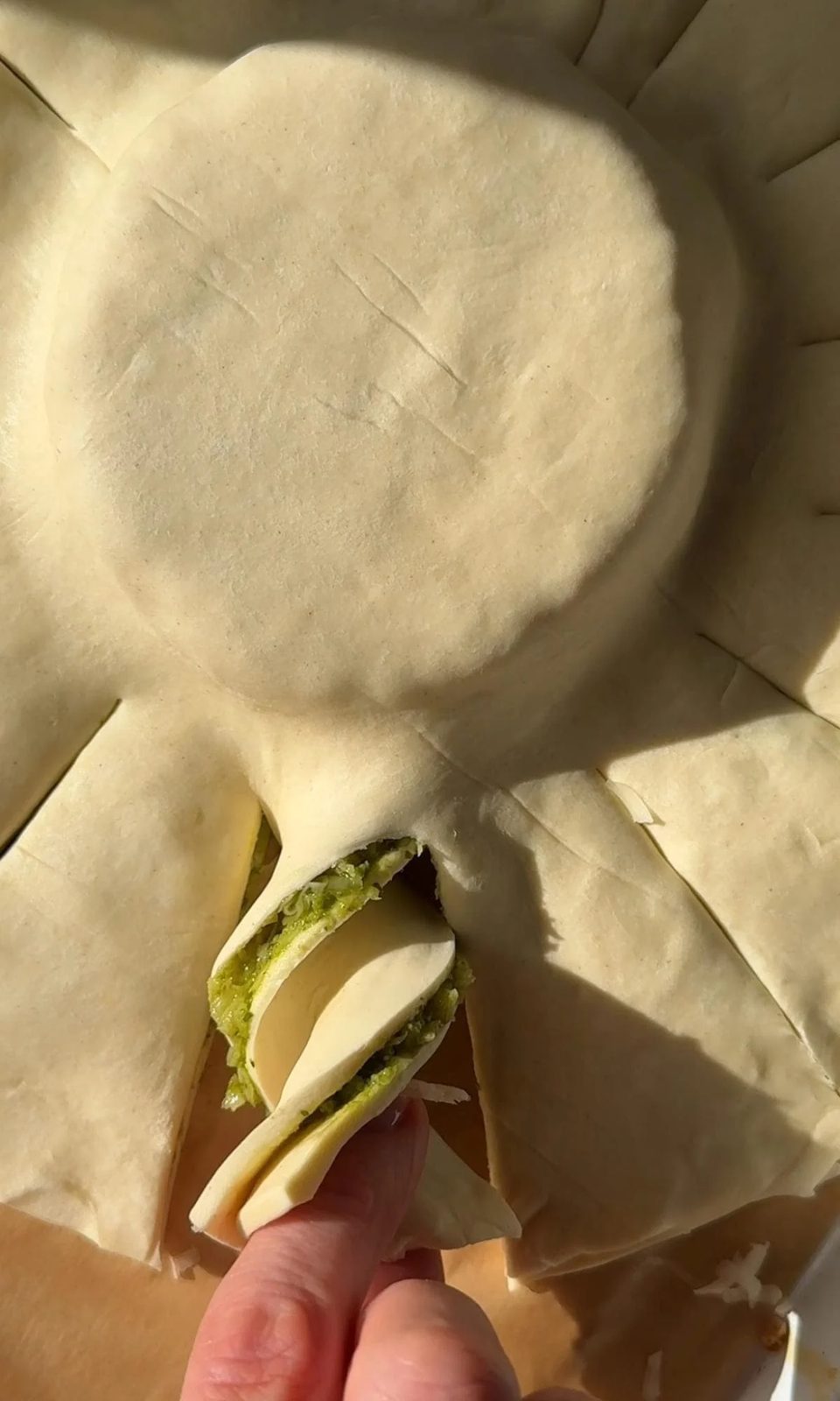 Twisting pesto-filled pastry strips.