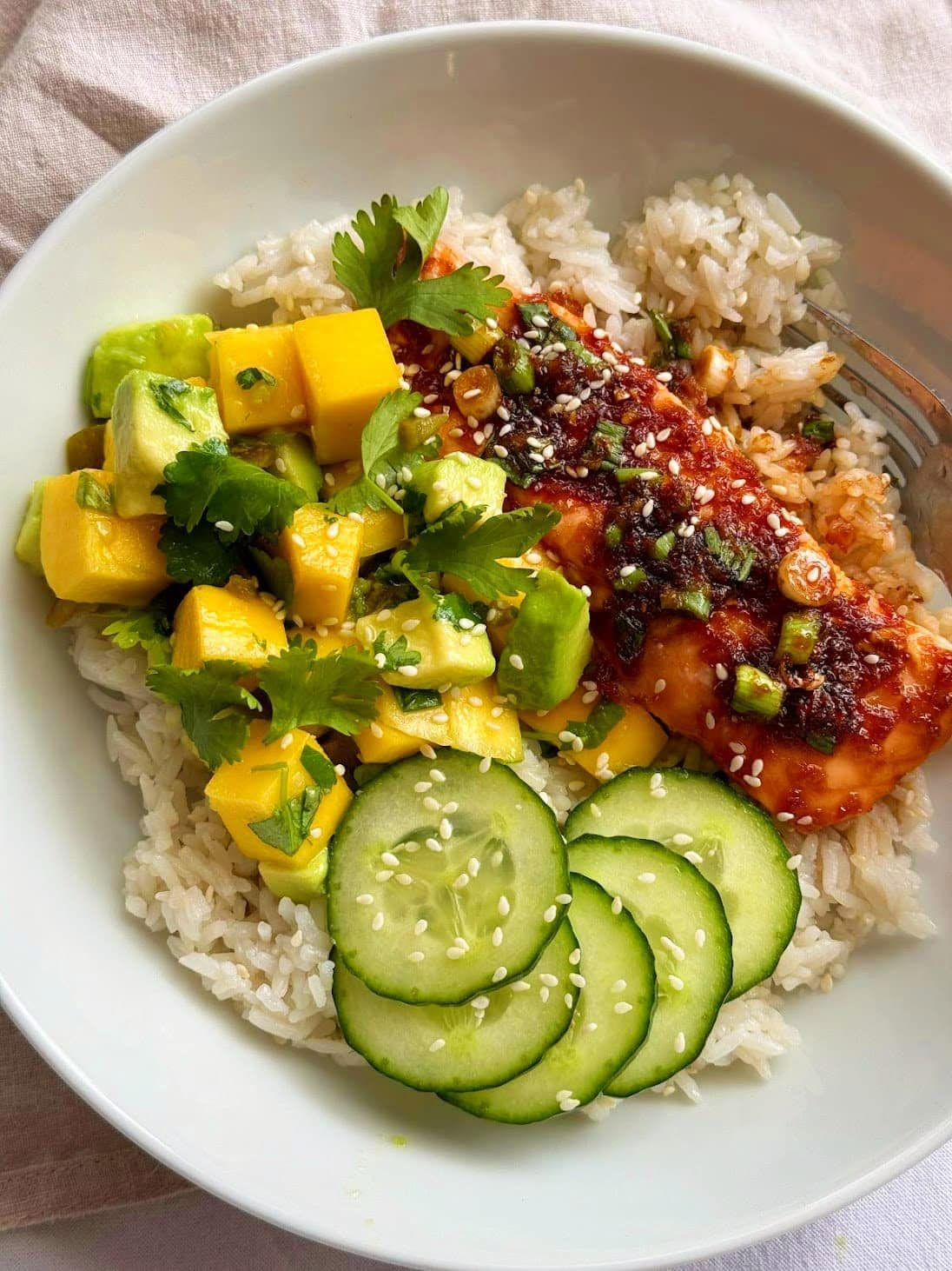 Teriyaki salmon bowl with mango avocado salsa and rice.