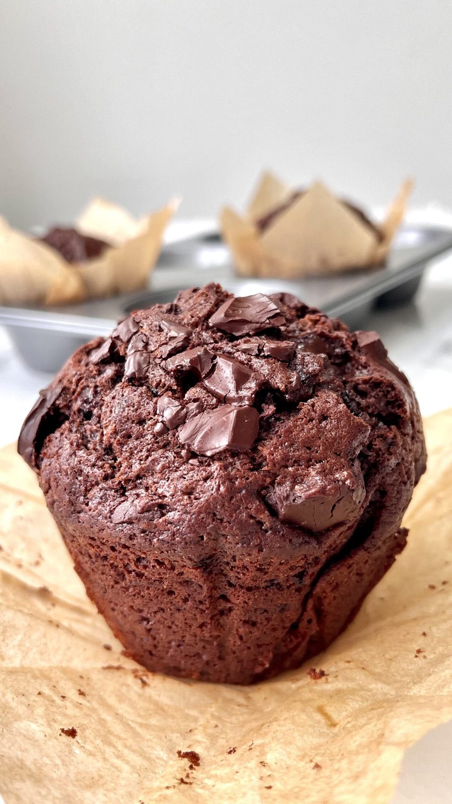 single chocolate chunk muffin on greaseproof paper