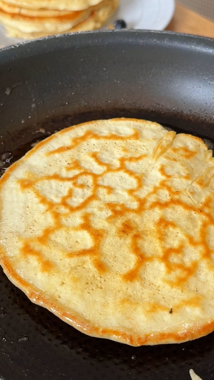 Cooking flipped pancake in pan.