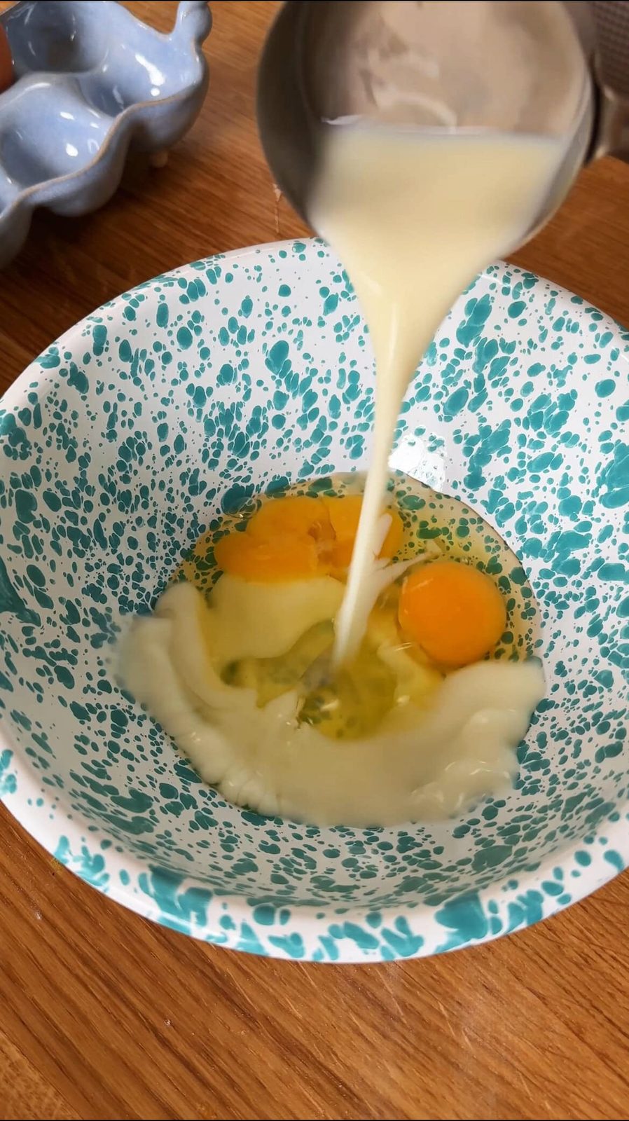 Pouring milk into bowl with eggs.