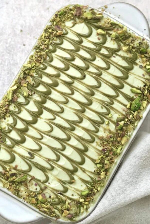 Pistachio tiramisu in white dish.